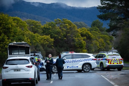 Police allow ambulance vehicles through a roadblock on Mt Buffalo Road, just west of Porepunkah