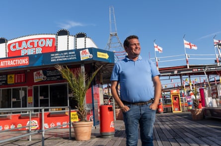 He stands on the pier, hands in his jeans, smiling