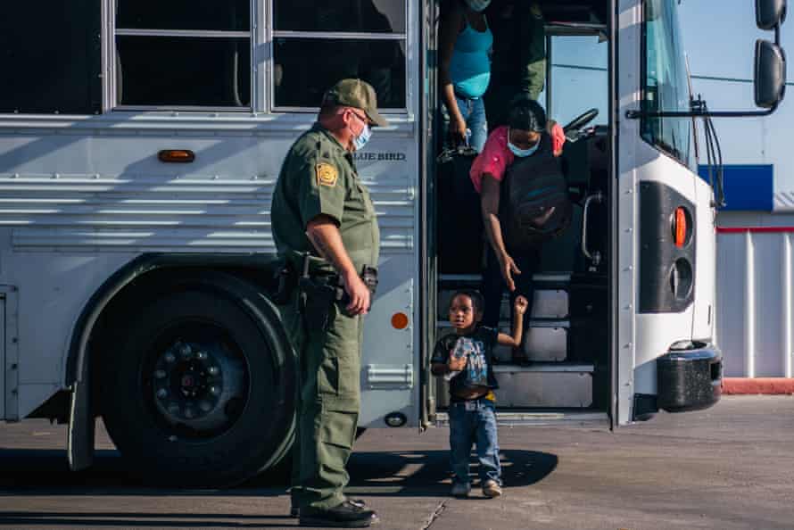 Migrants exit a Border Patrol bus and prepare to be received by the Val Verde Humanitarian Coalition after crossing the Rio Grande on September 22, 2021 in Del Rio, Texas.