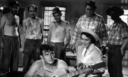 Andy Griffith with a guitar and Patricia Neal sitting beside him.