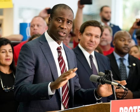 a man in a suit speaks into a microphone