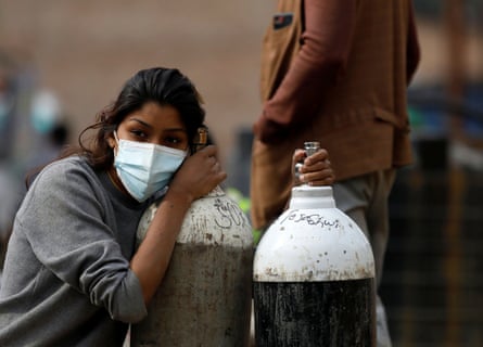 A woman in Kathmandu holds on to oxygen cylinders