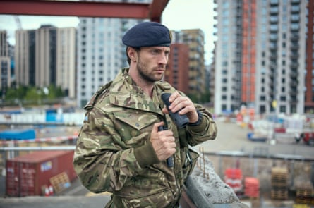 A man in an army uniform on a building site