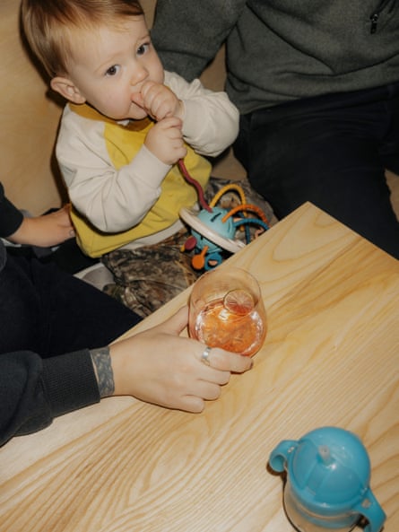 A baby in between two adults looking at the camera