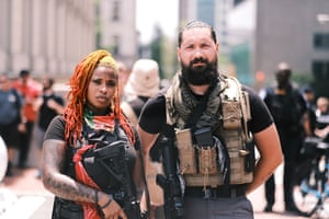 Two protesters carrying guns pose for photos during the open carry protest. People attended an event in Virginia tagged Stand with Virginia, Support the 2nd amendment