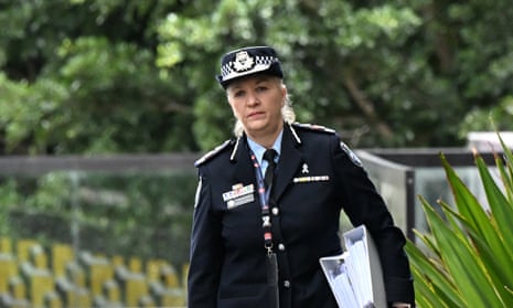 Woman in police uniform walks holding white folders