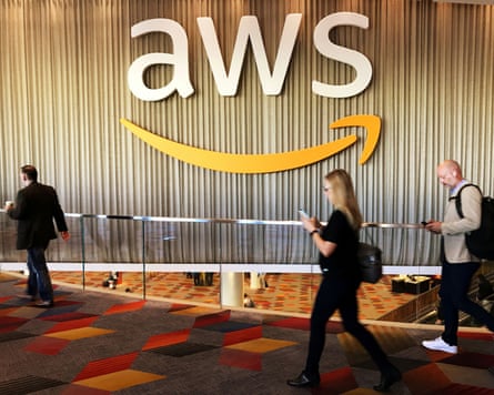 Attendees at an annual cloud computing conference walk past the Amazon Web Services logo