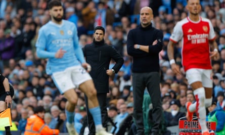 Mikel Arteta and Pep Guardiola watch from the touchline.