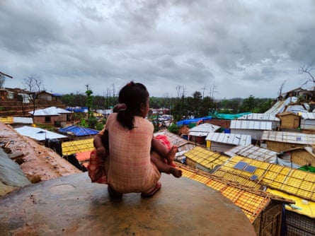 A young Rohingya girl holds her brother as she looks out onto the camps that have become her home. This photo won the Oxfam’s 2021 Rohingya Arts Competition.