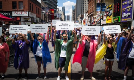 Pride parade participants display names of the Orlando Pulse nightclub victims on Yonge Street during a moment of silence in Toronto on 3 July 2016.