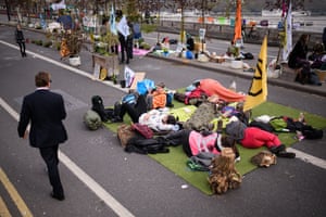 Protestors rest in the middle of the road as environmental campaigners continue to block Waterloo Bridge in London, UK