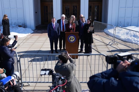 a woman speaks into a microphone outside