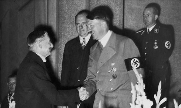 Neville Chamberlain shakes hands with Adolf Hitler eight days before signing the Munich agreement.