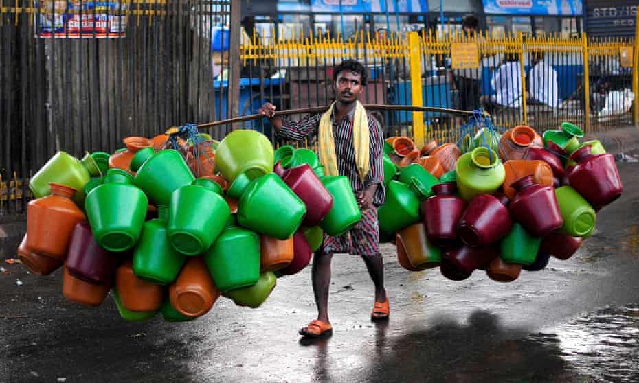 A man carries empty water pitchers