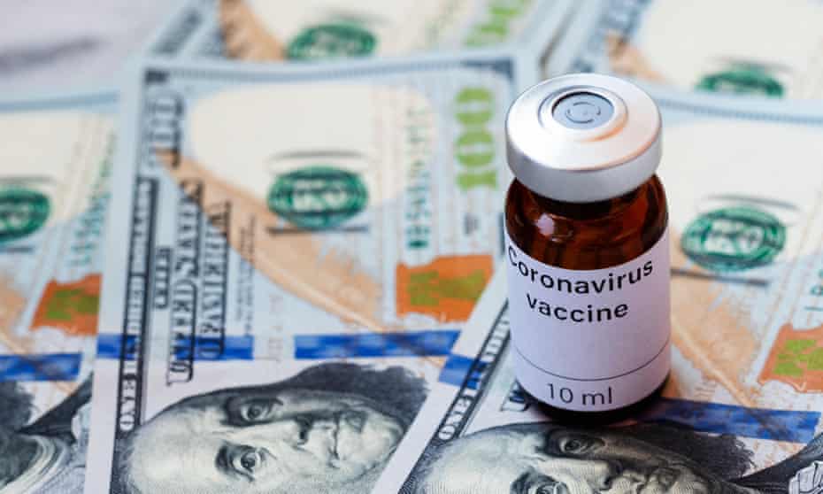 A pill jar marked coronavirus vaccine sits on top of dollar notes