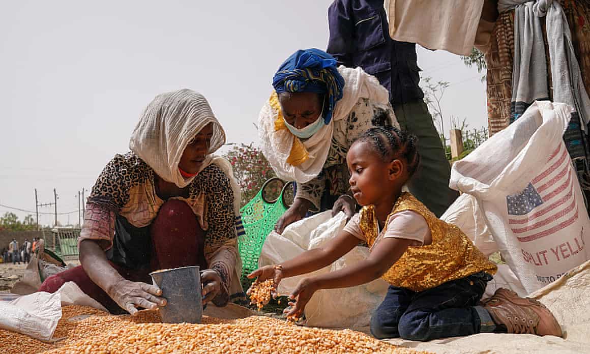 An aid worker gives food to people in need in Mekele.