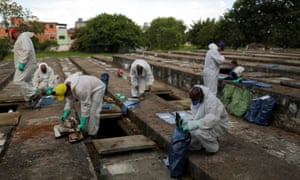 Gravediggers wearing protective suits.