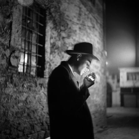 A young man lighting a cigarette in the dark in Beyoğlu, 1954, by Ara Güler.