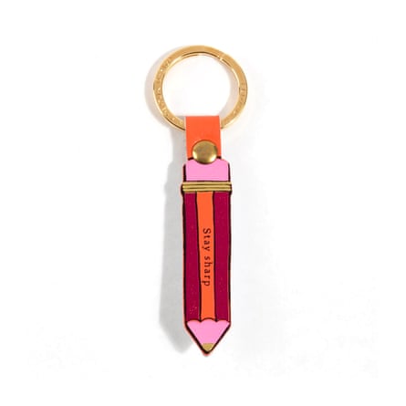 A pencil-shaped fob with a red, orange and pink pencil illustration on a simple gold ring.