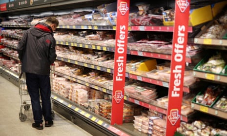 A shopper walks along the meat aisle inside an Aldi supermarket near Altrincham