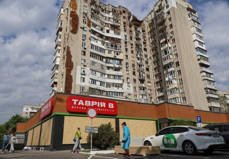 People walk near the apartment building hit by a Russian drone strike, amid Russia's attack on Ukraine, in Odesa.