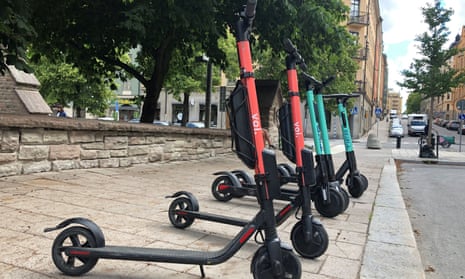 Electric scooters sit parked alongside a kerb in Stockholm