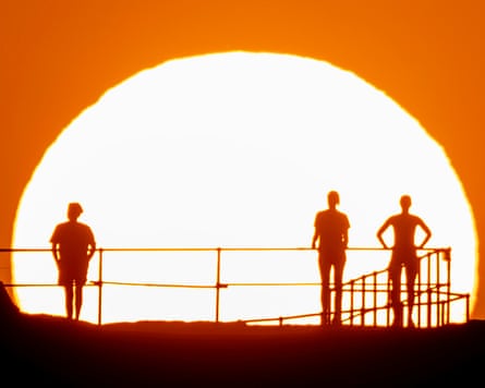 Silhouettes of people against a bright sun.