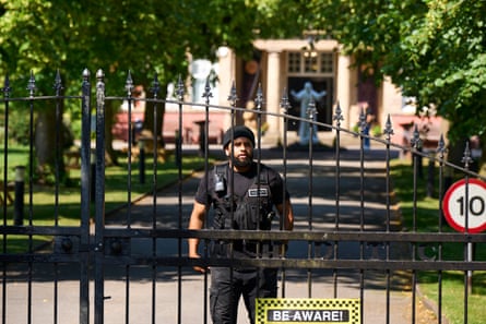 A man in a black beanie with building and religious statue in background