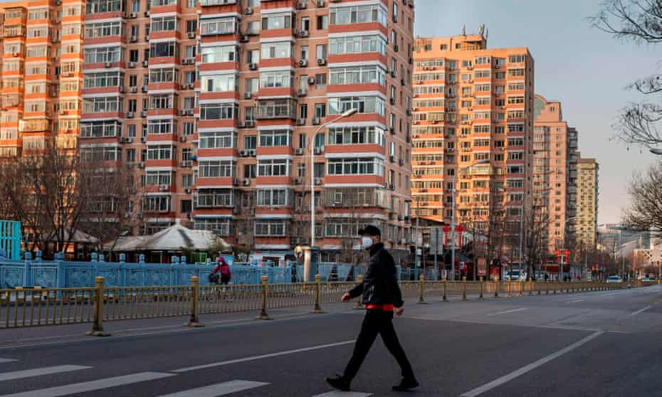 A man wearing a protective mask walks along an empty street in Beijing.