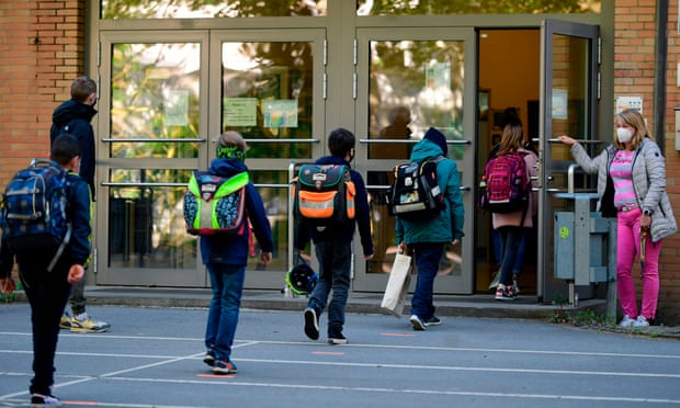 Children respect physical distancing rules at a reopened school in Dortmund