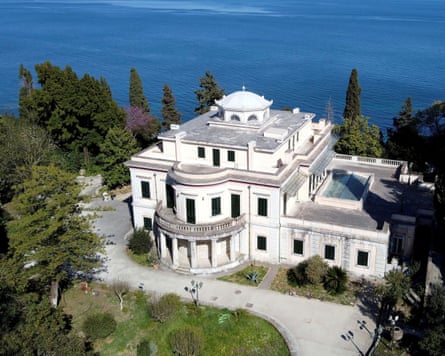Mon Repos, white villa on hillside among trees overlooking very blue sea