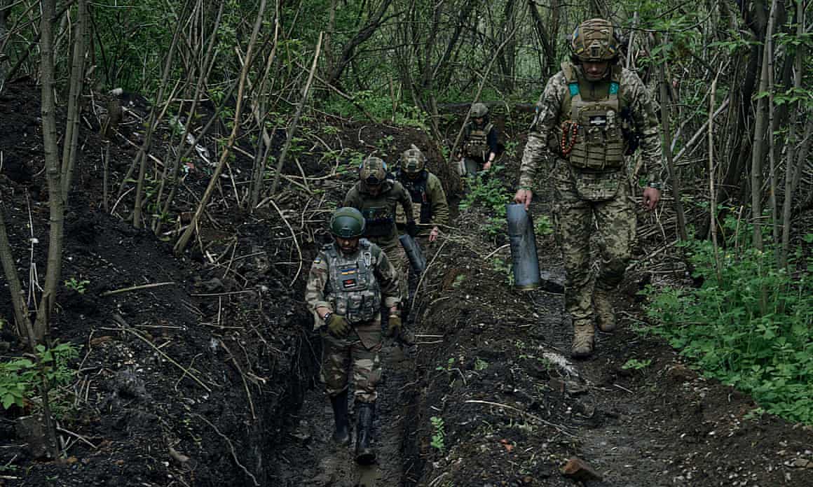Ukrainian soldiers walk in a trench near Bakhmut, an eastern city where fierce battles against Russian forces have been taking place, in the Donetsk region, Ukraine, Saturday, April 29, 2023. (AP Photo/Libkos)