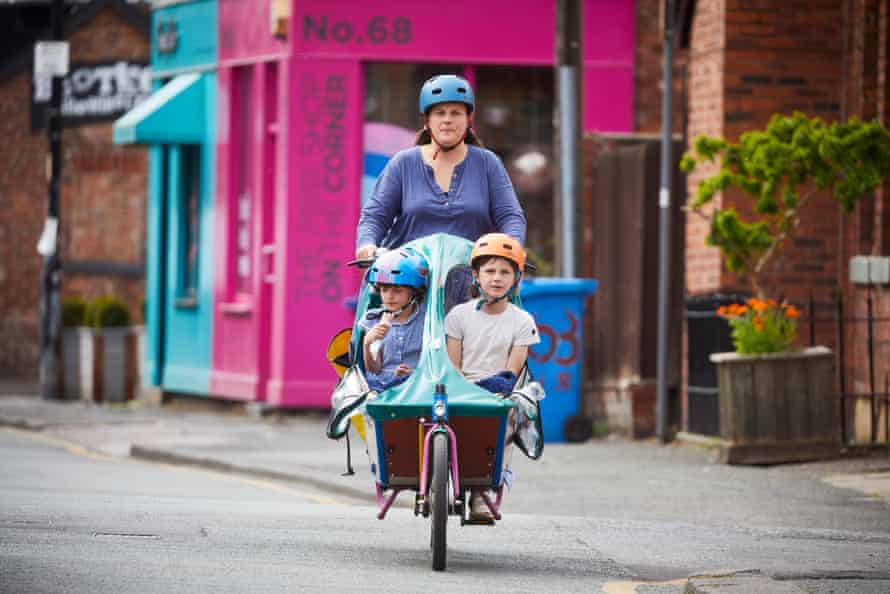 27 May – A family cycles past independent shops in Chorlton, south Manchester