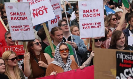 People hold placards reading 'smash racism/smash the far right'
