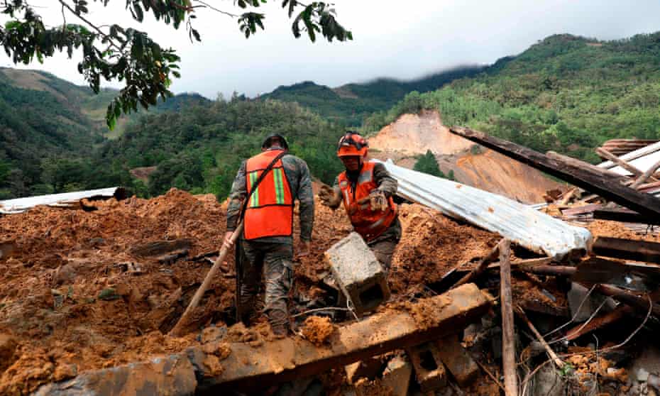 Rescue workers search for victims of a musdlide caused by the passage of Storm Eta in the village of Queja, Guatemala.
