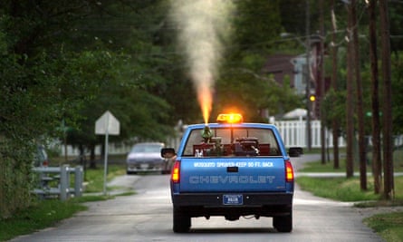A truck sprays for mosquitoes in residential neighborhoods.