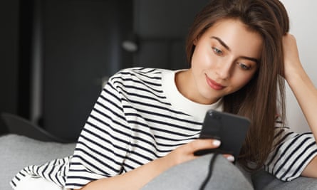 A young woman looks at her phone