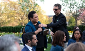 A White House aide attempts to take the microphone out of the hands of correspondent Yamiche Alcindor as she questions Donald Trump.