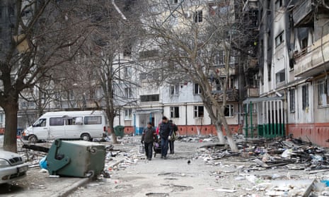 People outside a badly damaged block of flats in Mariupol, Ukraine