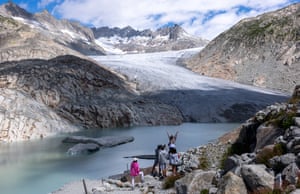 Tourists posing for a picture in front of the melting Rhône glacier