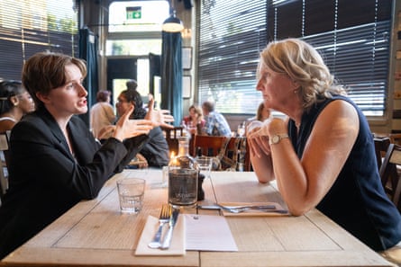 Margaret and Clare clink chat across a restaurant table