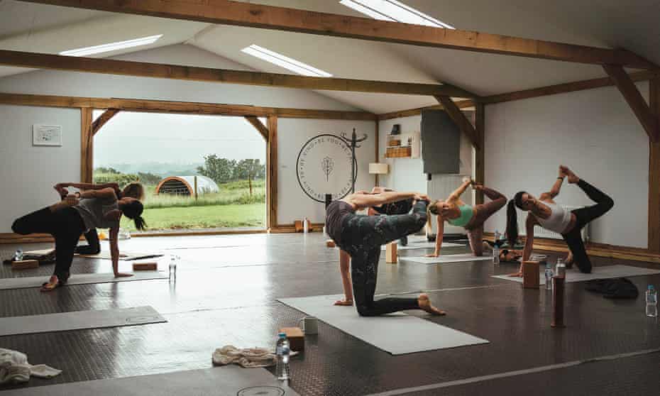 A small group practises yoga on the three-day retreat at Fair Oak Farm, East Sussex, UK