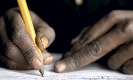 Boy at school, writing, in Tanzania