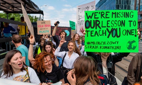 Teenage protesters in Warsaw, Poland, hold up placards calling on politicians to address climate crisis.