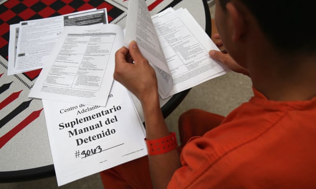 An immigrant detainee reads through paperwork in a general population block at the Adelanto detention facility.