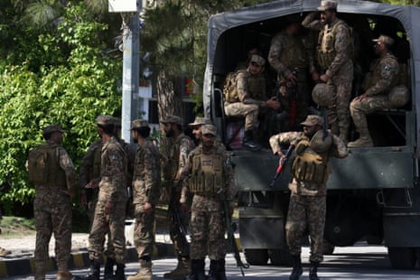 एक दर्जन से अधिक वर्दीधारी और हथियारबंद लोग एक सैन्य वाहन के पास या उसके अंदर खड़े थे।