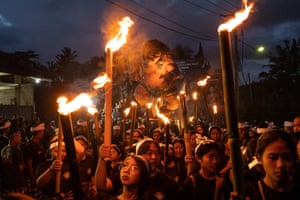 Women hold bamboo torches during the ogoh-ogoh parade on the eve of Nyepi, the Balinese Hindu Day of Silence, that marks the arrival of the new lunar year.