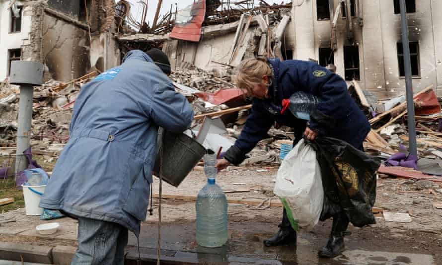 Escape from Mariupol: the man who swam to safety from Russian terror | Ukraine 1 Residents draw water from a well near the destroyed theatre in Mariupol.