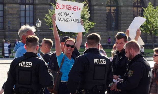 Protestor holding a sign surrounded by police