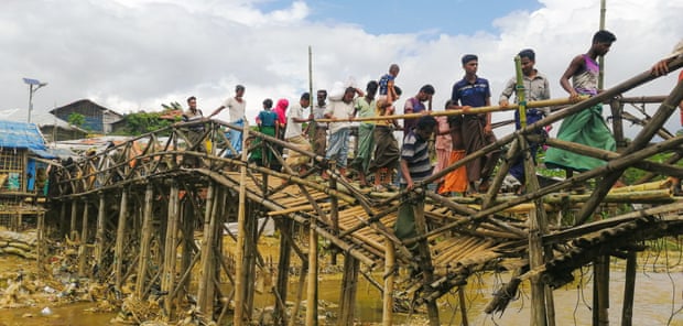 Rohingya-flyktninger krysser en elv inne i leiren over en skadet bro. Et fotografi av Sahat Zia Hero.